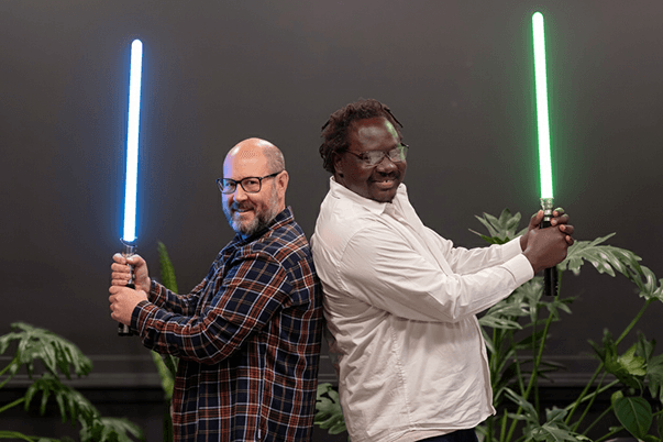 Javier Borkenztain and Robert Jakech holding lightsabers